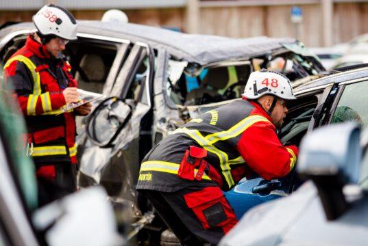 Bombero rescatando a una persona de un vehículo accidentado en el centro de seguridad de Volvo.