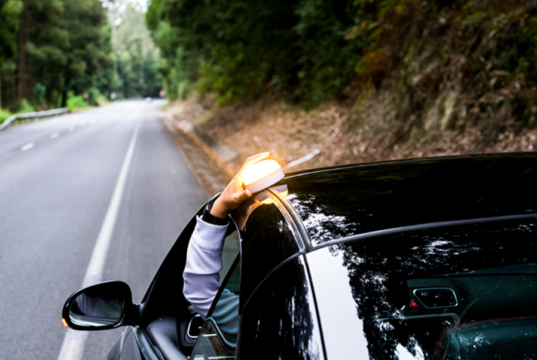 Baliza V16 conectada sobre un vehículo en un artículo sobre su obligatoriedad y el debate abierto tras más de 100 días