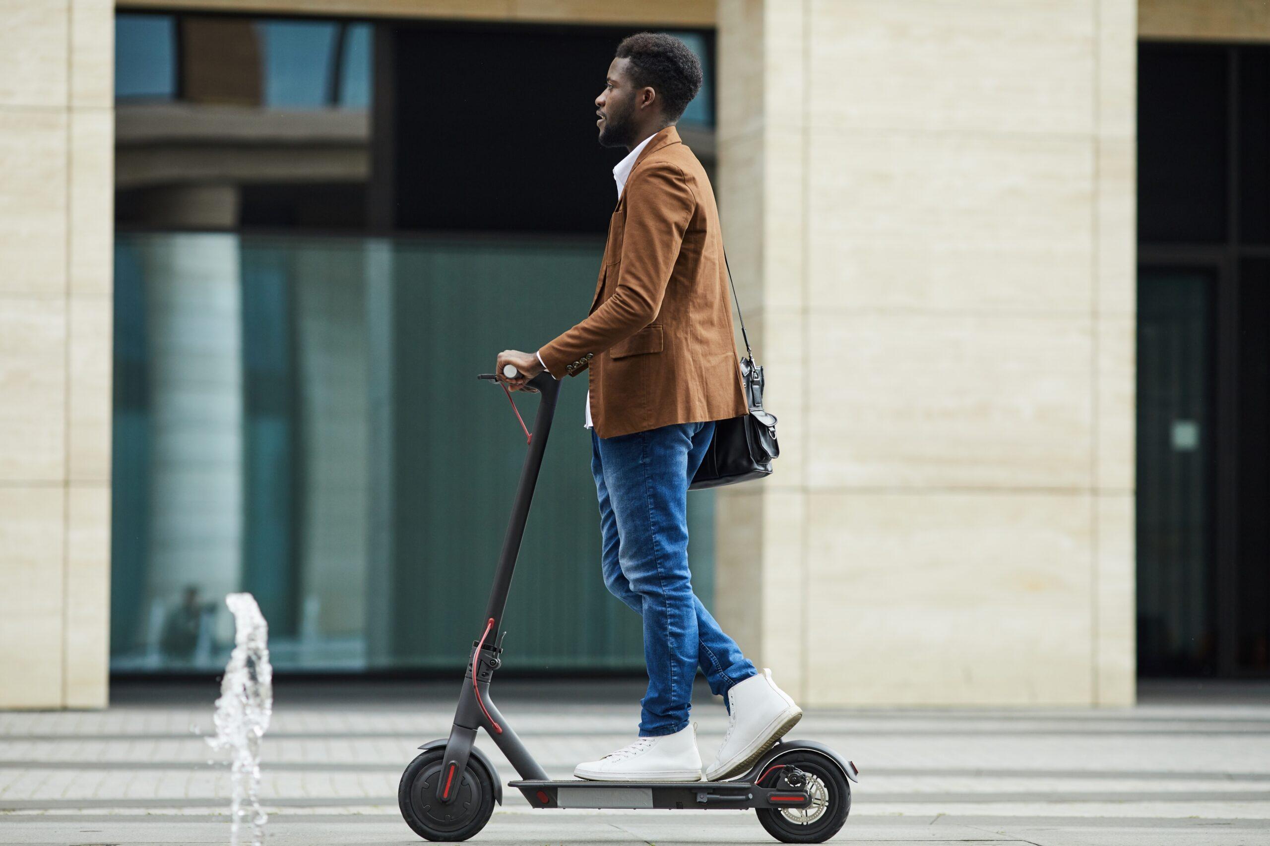 ciudadano desplazándose por ciudad en un patinete eléctrico