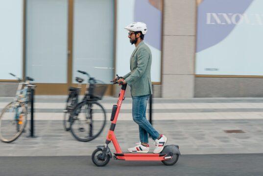 Usuario de patinete eléctrico VMP circulando con casco