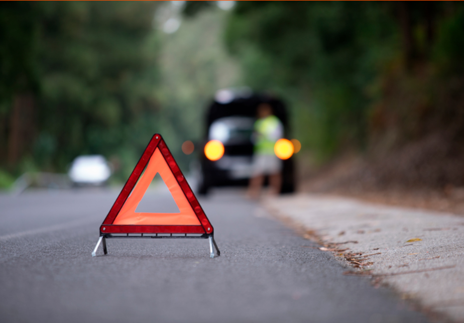 Vehículo detenido en la calzada detrás del triangulo de preseñalización de emergencia