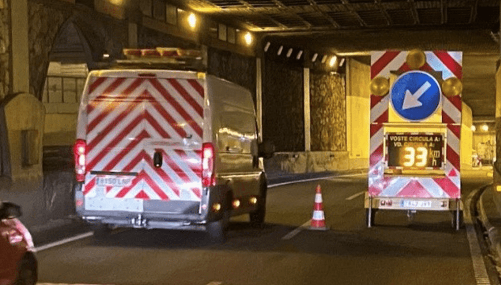 TRABAJO DE MANTENIMIENTO EN CARRETERA 2 Vehículos circulando junto a operarios y señalización en un tramo de carretera en obras