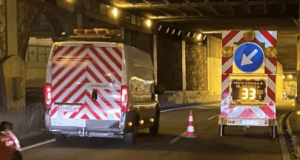 Vehículos circulando junto a operarios y señalización en un tramo de carretera en obras
