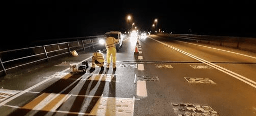 Vehículos circulando junto a operarios y señalización en un tramo de carretera en obras