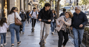Patinetes eléctricos circulando por una acera entre peatones en un entorno urbano, ejemplo de conflicto de convivencia y seguridad vial en la ciudad.