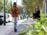 Patinetes eléctricos: el 92% de los españoles pide más control para mejorar la seguridad vial Usuario de patinete eléctrico circulando por una vía urbana habilitada, con casco y respetando el espacio de los peatones.